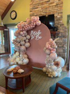 Un décor festif de Baby Shower avec des ballons colorés, une table joliment dressée et des éléments personnalisés pour célébrer l'arrivée d'un bébé."
